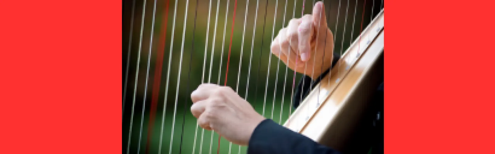 Hands playing a harp musical instrument