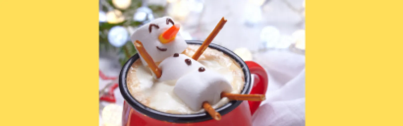 Marshmallow snowman laying in a red cup of hot chocolate
