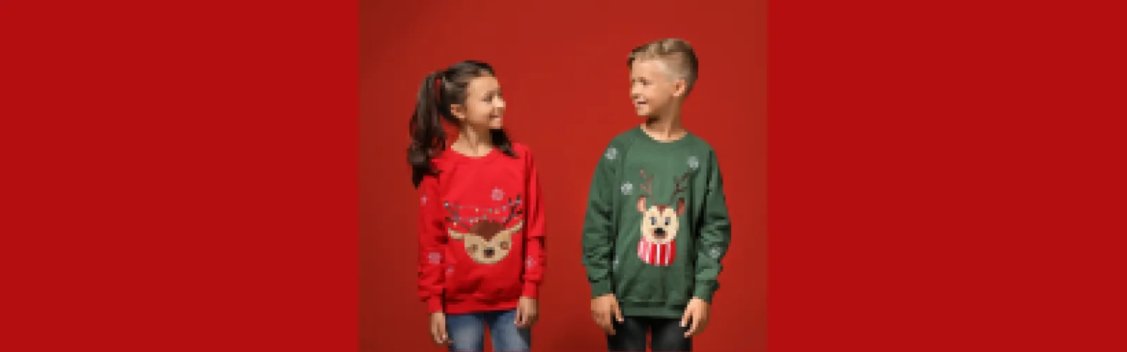 Boy and girl wearing Christmas sweaters looking at each other