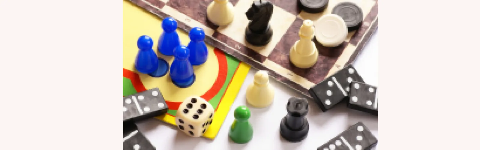 Chess pieces, dice, and board game pieces along boards to play games on