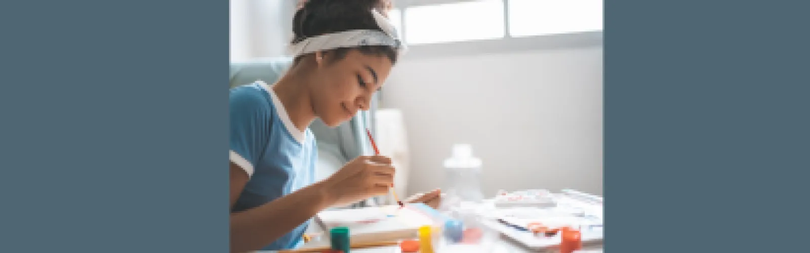 Teen girl looking down and painting