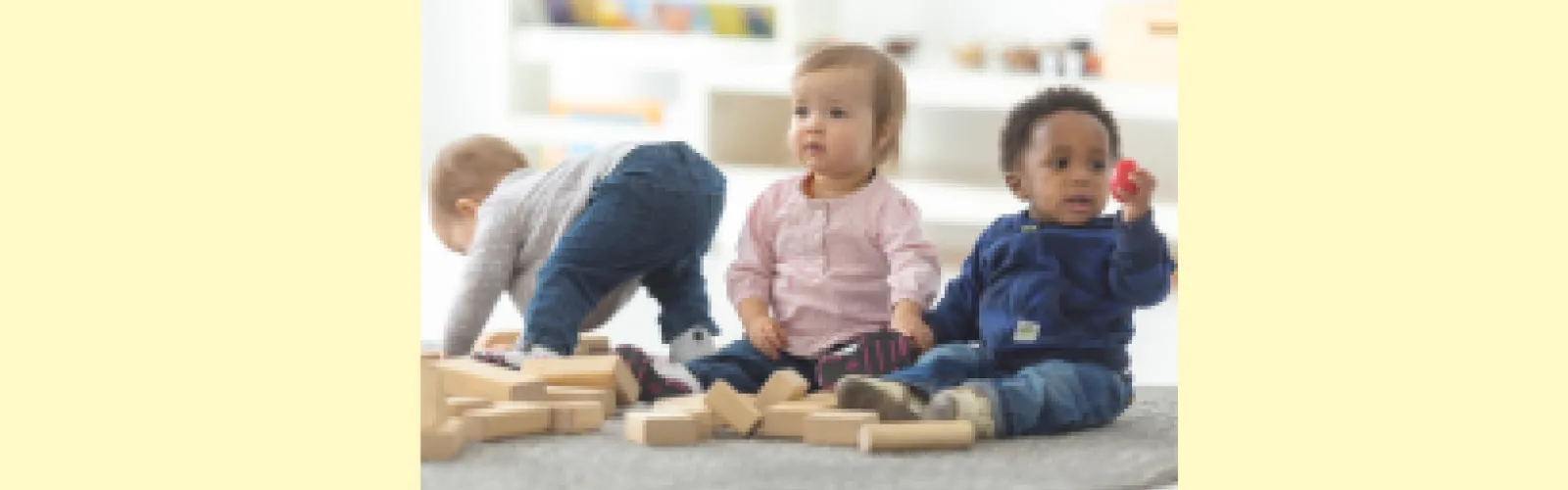 Three toddlers playing with blocks