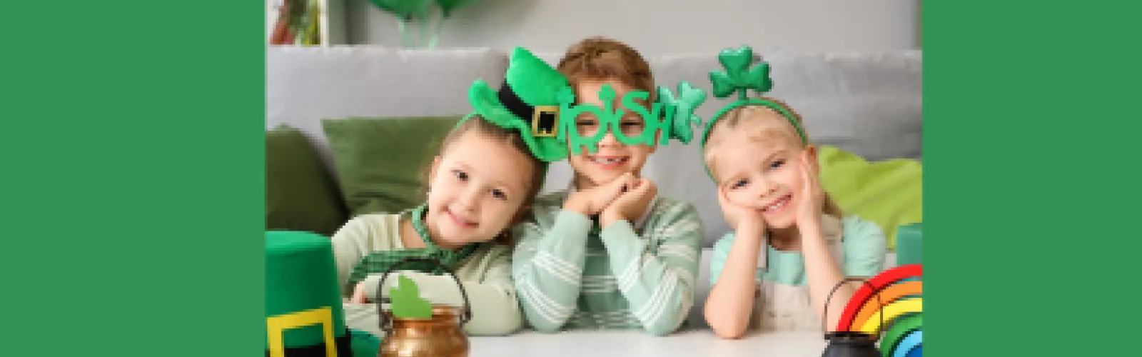 Three children dressed in green on green background