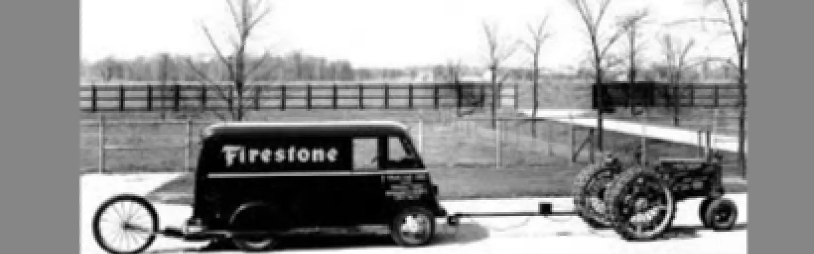 Historical photo of the Firestone Farm Tire Test Center with two vehicles in black and white