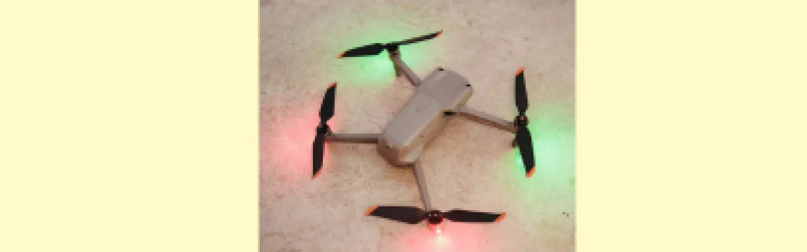 Drone with four arms with pink and green lights