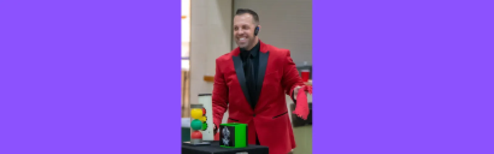 Rick Everhart in a red jacket performing a magic trick