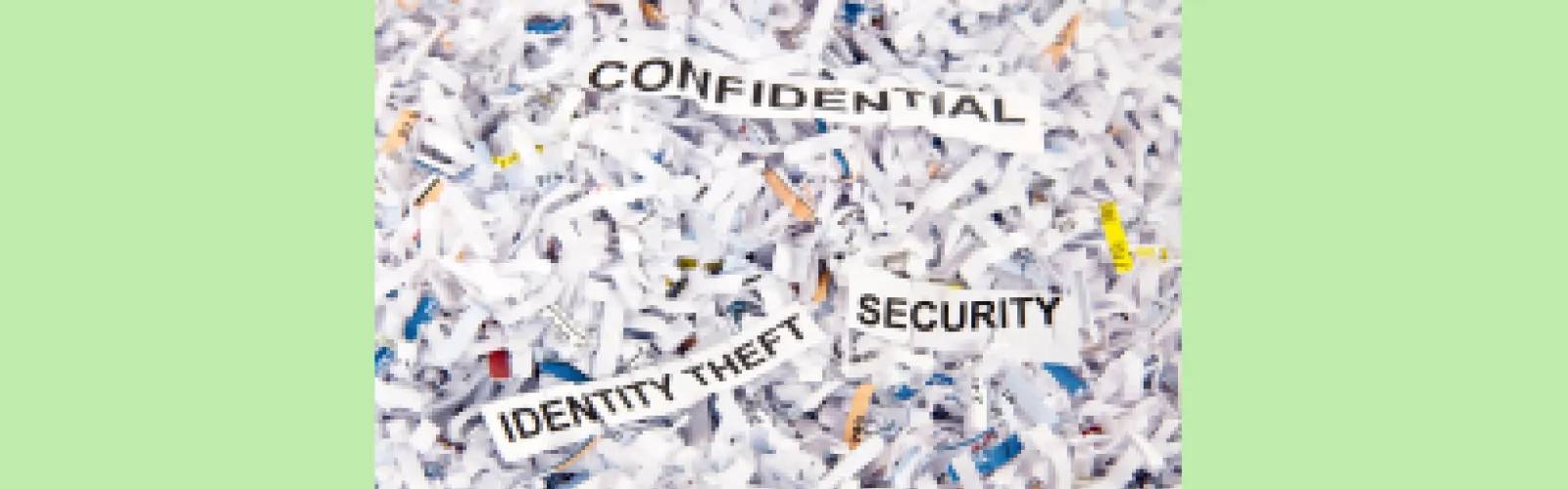 Shreds of paper with the words "confidential," and "identity theft security"