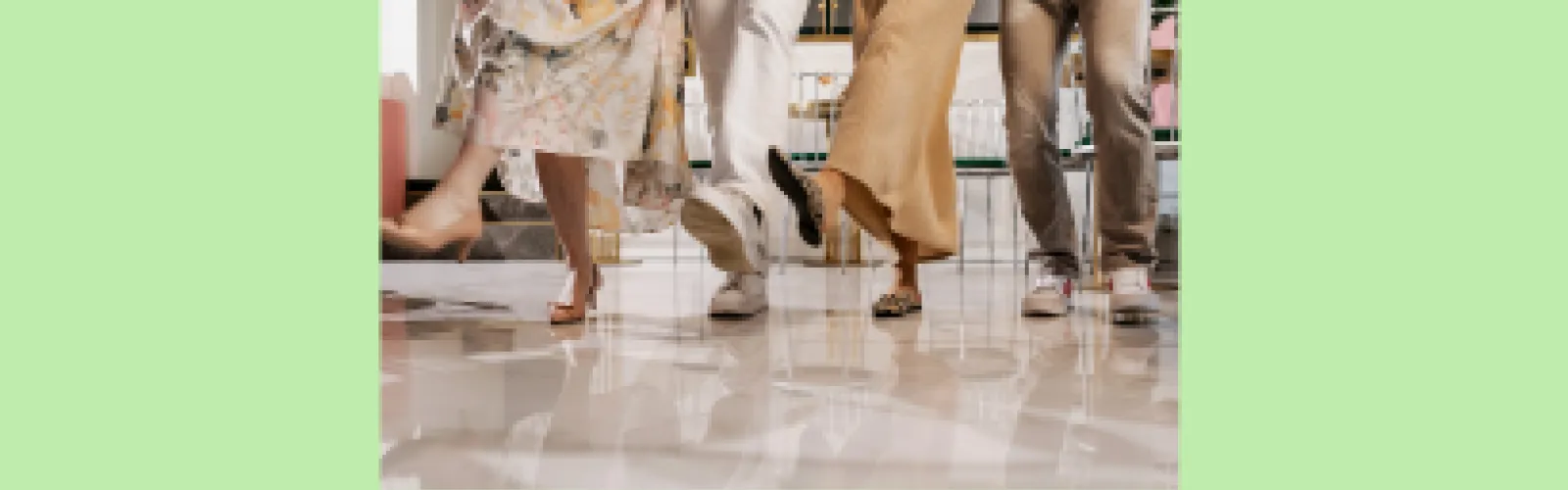 Legs of adults kicking or dancing on brown floor with a green background